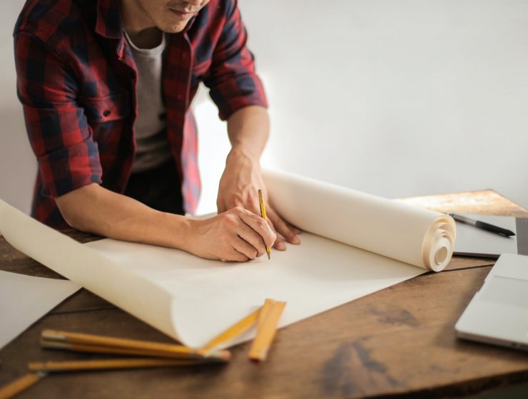 Astro: inteligencija, male constructor drawing draft on paper roll