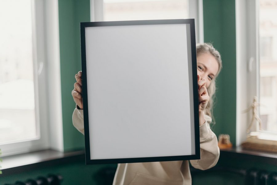 woman holding white and black frame