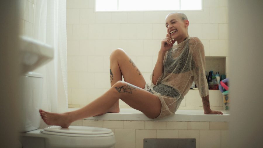 smiling woman sitting on bath tub