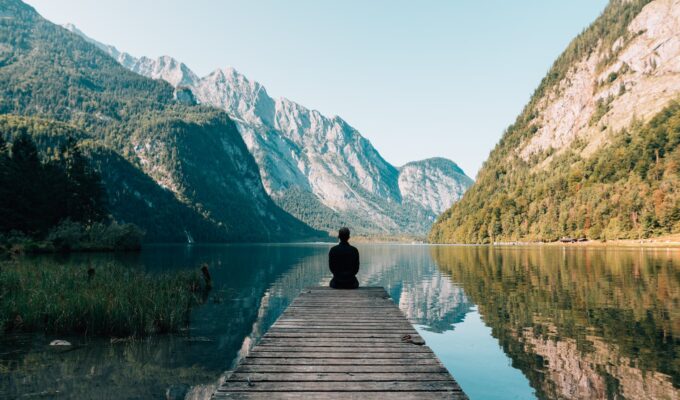 Živjeti po mjerilu duše, a person sitting on wooden planks across the lake scenery