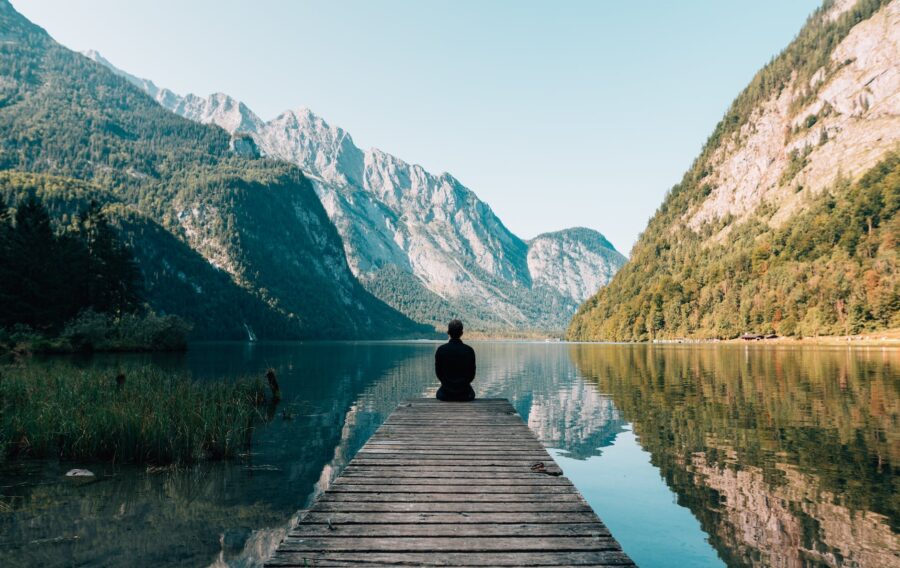 Živjeti po mjerilu duše, a person sitting on wooden planks across the lake scenery
