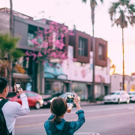 Živjeti u trenutku unrecognizable tourists taking pictures on smartphone of tropical city street