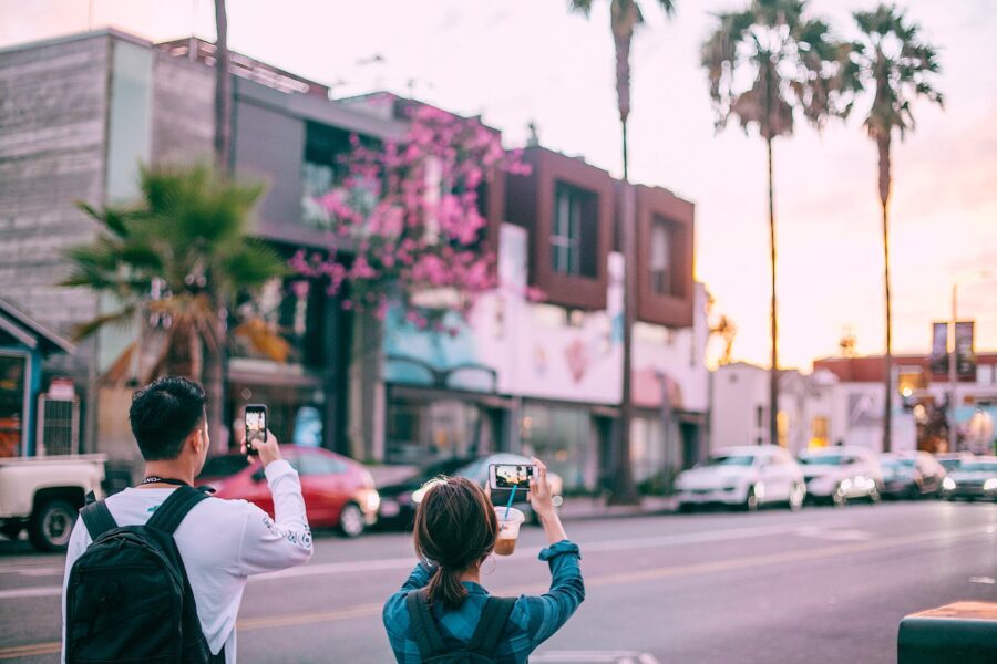 Živjeti u trenutku unrecognizable tourists taking pictures on smartphone of tropical city street