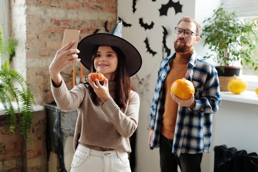 Venera u Škorpionu, a couple holding pumpkins while taking selfie photo